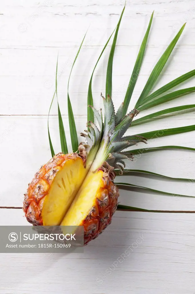 Slices pineapple on palm leaf, studio shot