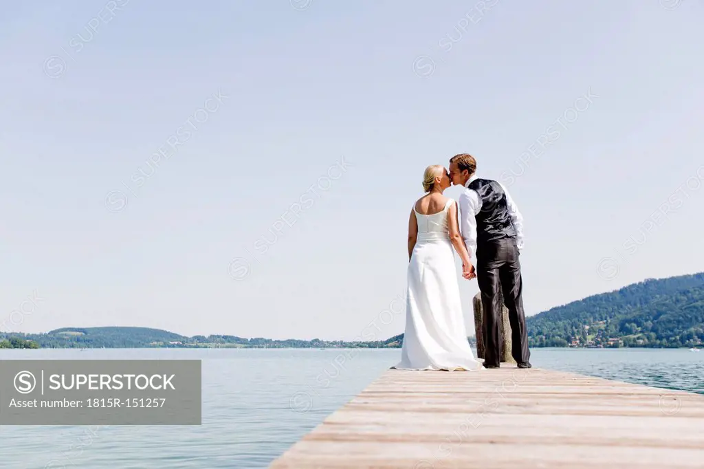 Germany, Bavaria, Tegernsee, Wedding couple standing on jetty