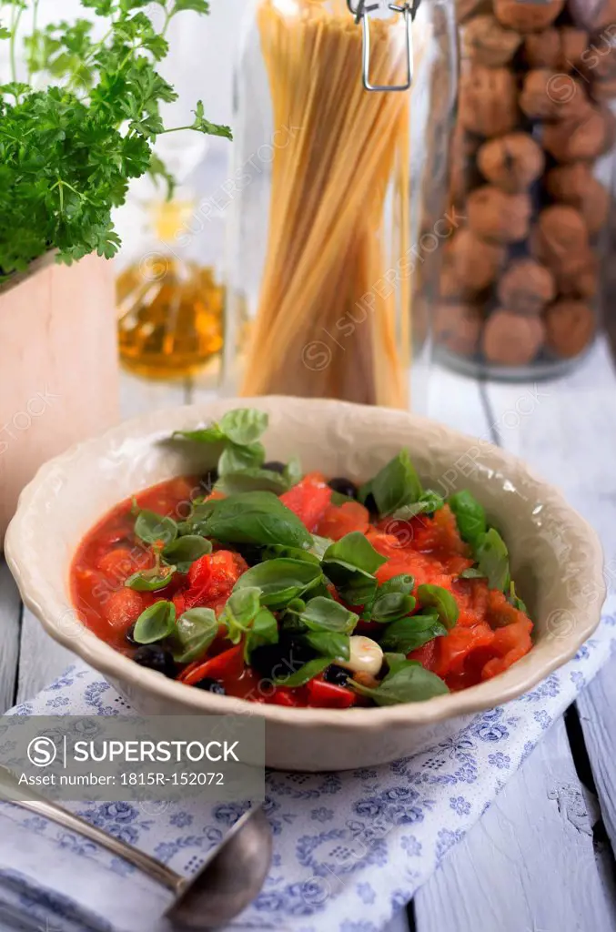 Sauce made of grilled tomatoes with black olives and leaves of basil, studio shot