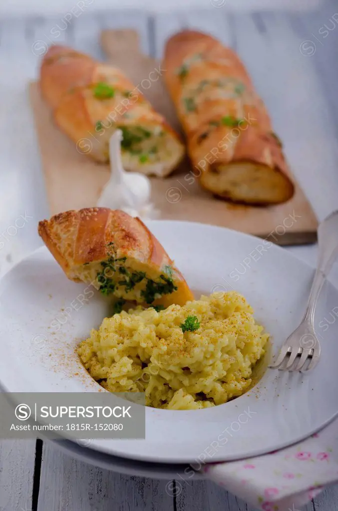 Curry rice and slice of garlic bread garnished with parsley, studio shot