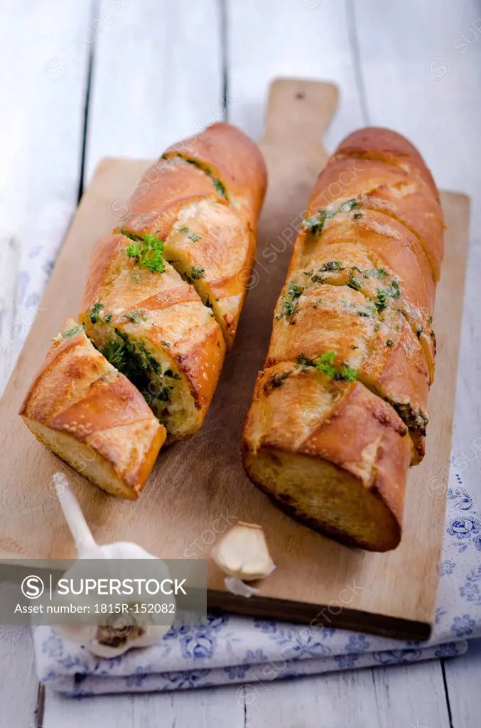 Sliced garlic bread garnished with parsley, studio shot