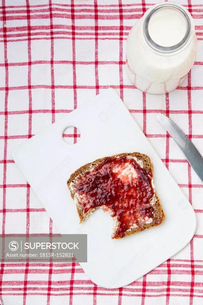 Slice of rye bread with jam on chopping board