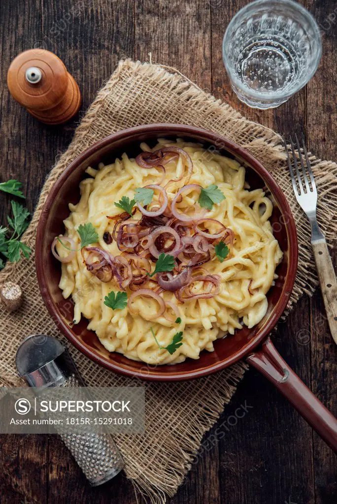 Traditional swabian cheese spaetzle, egg noodles with cheese, cream, roasted onions