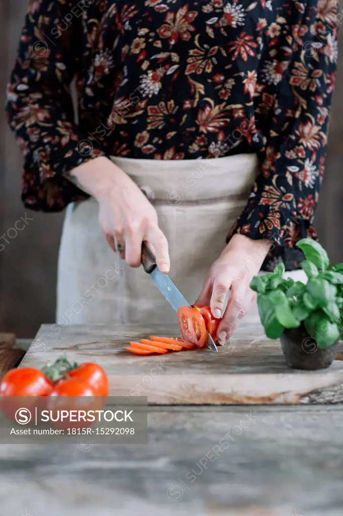 Woman preparing Caprese Salad, partial view