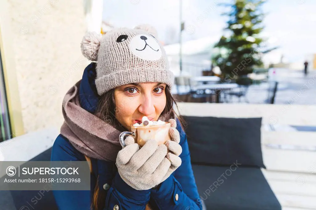 Portrait of woman drinking glass of hot chocolate with whipped cream