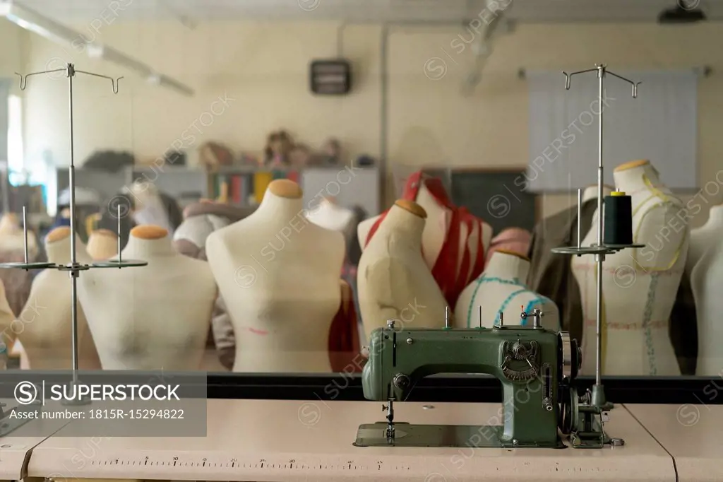 Dressmaker's models and sewing machine in fashion designer's studio