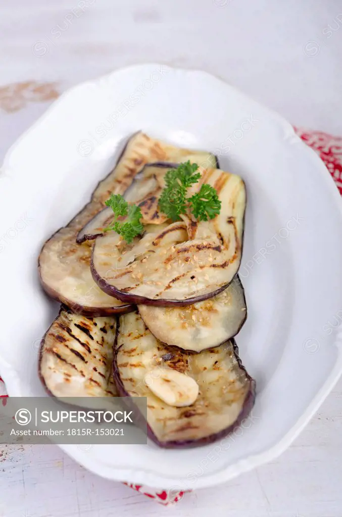 Roasted slices of eggplant on plate, studio shot