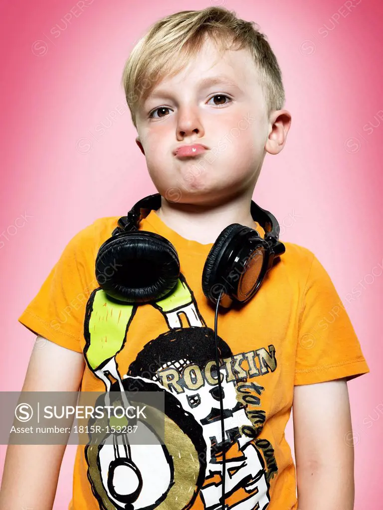 Portrait of pouting little boy with headphones, studio shot
