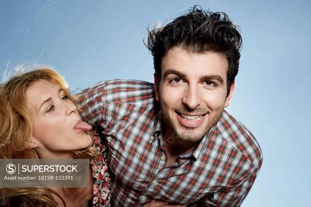 Germany, Dusseldorf, Young couple, woman sticking tongue out