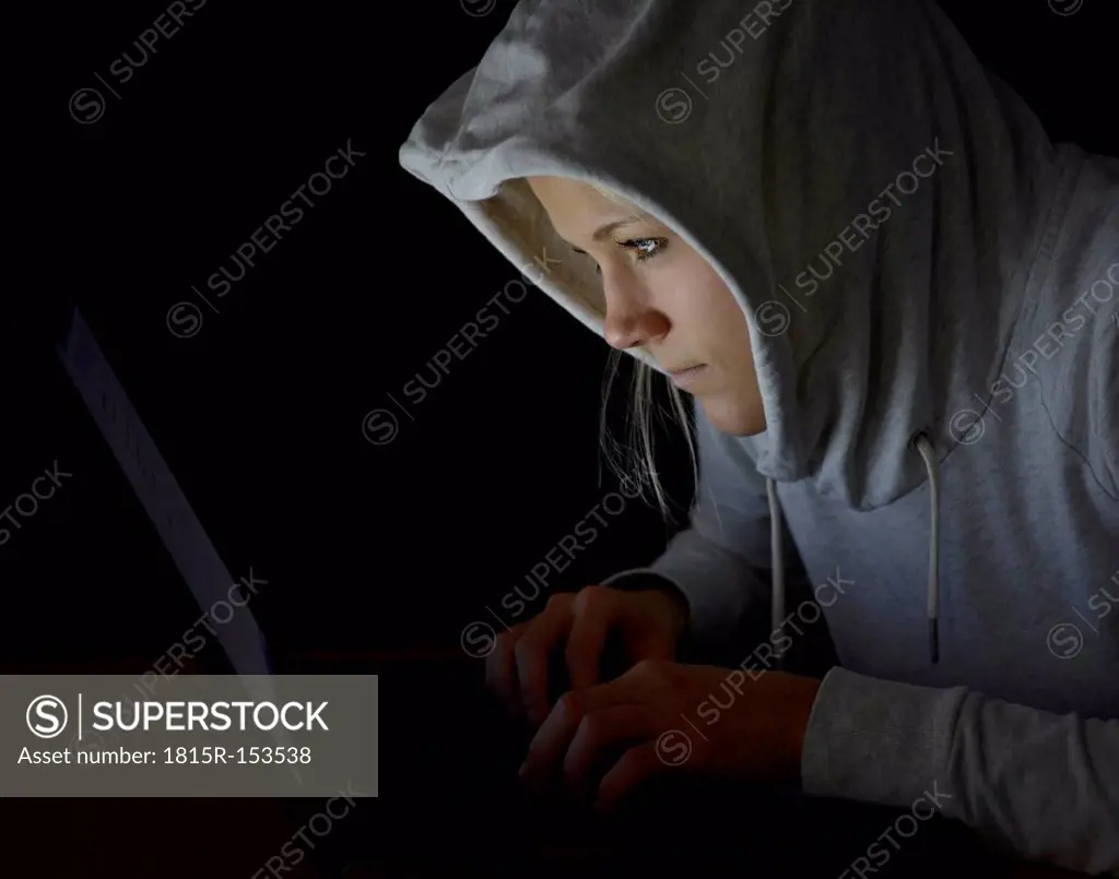 Young woman using laptop by night