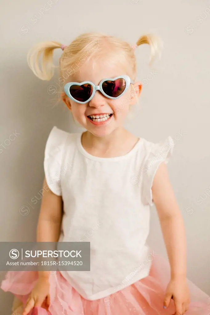 Portrait of blond little girl wearing heart-shaped sunglasses