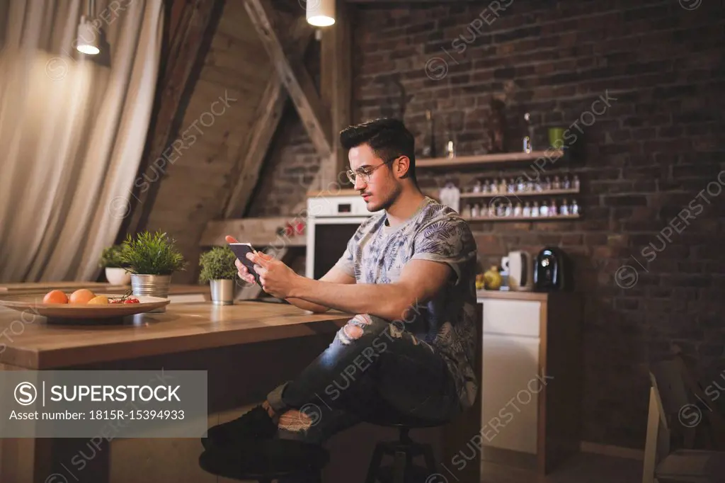 Young man using tablet in kitchen at home