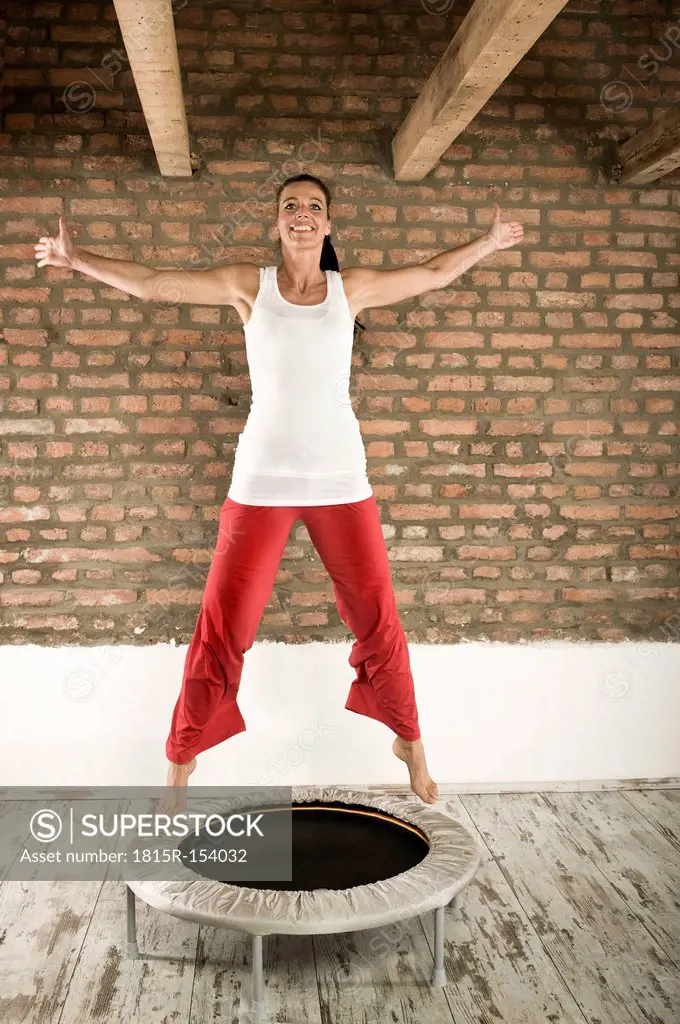 Germany, Bavaria, Woman jumping on trampoline