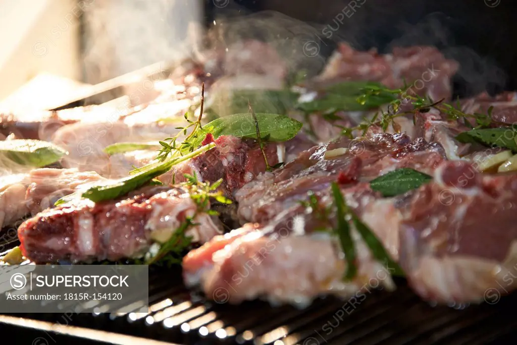 Marinated raw lamb chops on barbecue grill