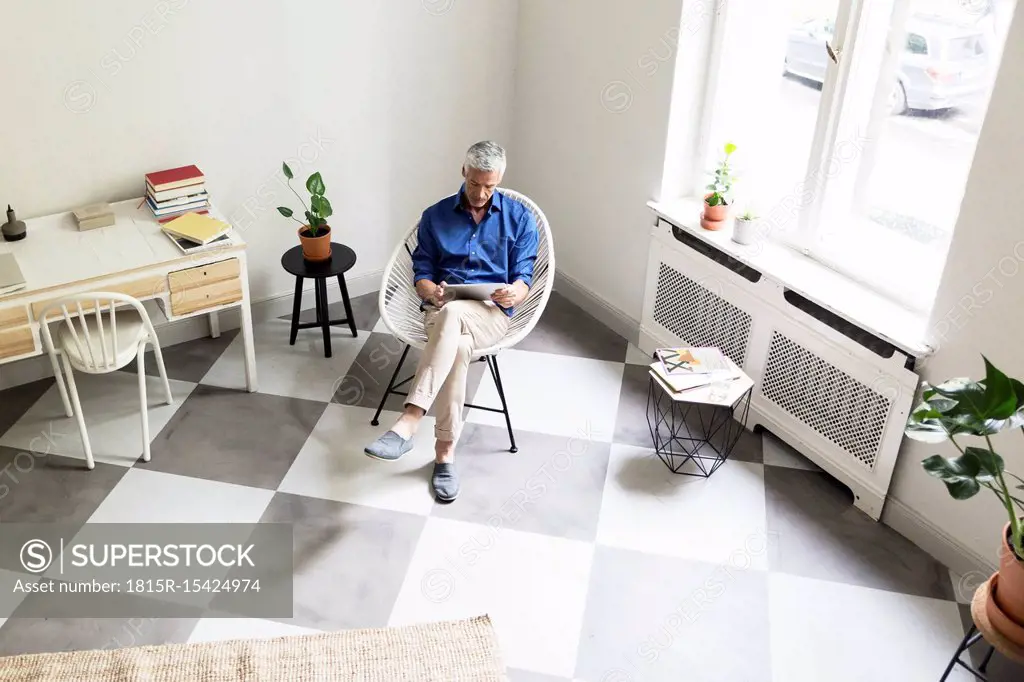 Mature man using tablet at home