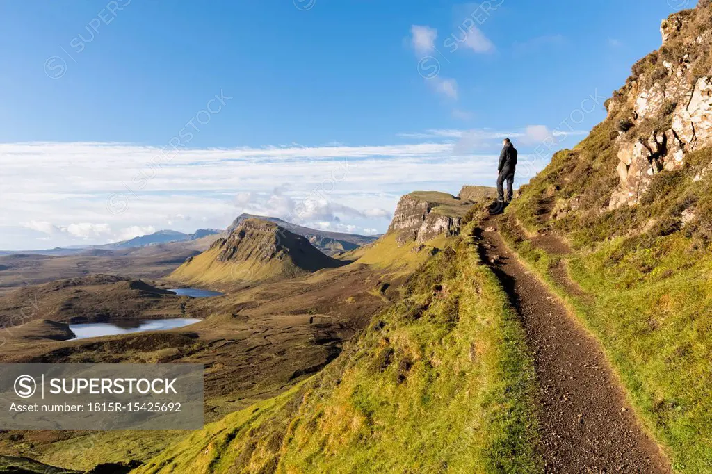 UK, Scotland, Inner Hebrides, Isle of Skye, Trotternish, hiking trail at Quiraing, Loch Cleat, hiker looking at view