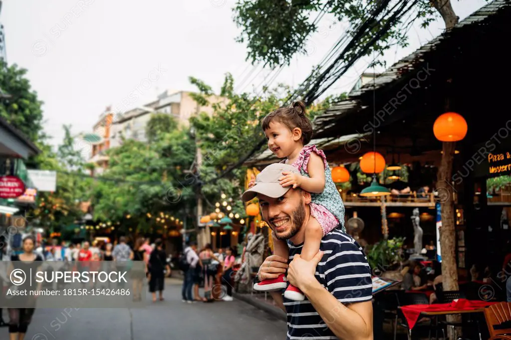 Thailand, Bangkok, portrait of smiling father and daughter on Khao San Road