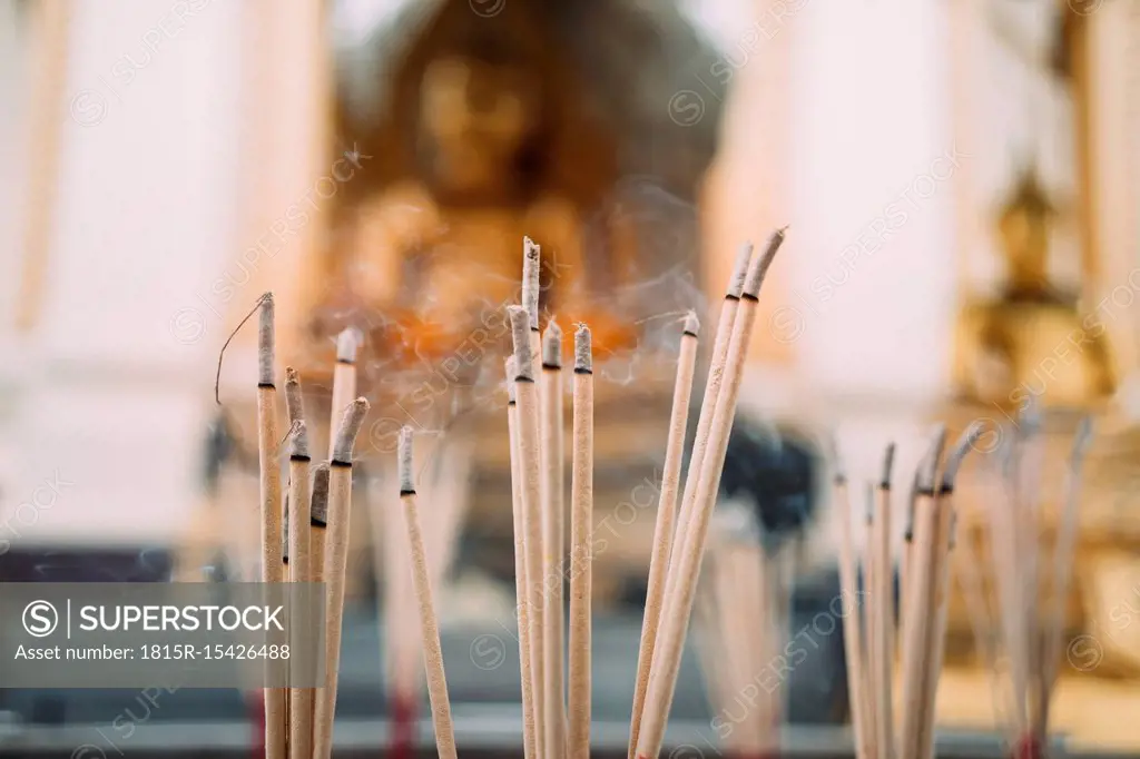 Thailand, Bangkok, incense burning in front of Buddha statues in a Buddhist temple