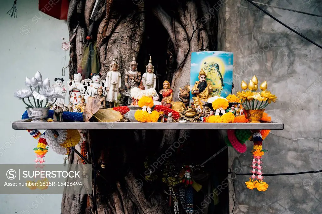 Thailand, Bangkok, Altar with Buddhist religious figures in a tree