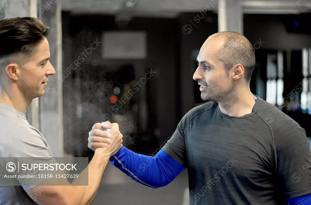 Two men shaking hands in gym