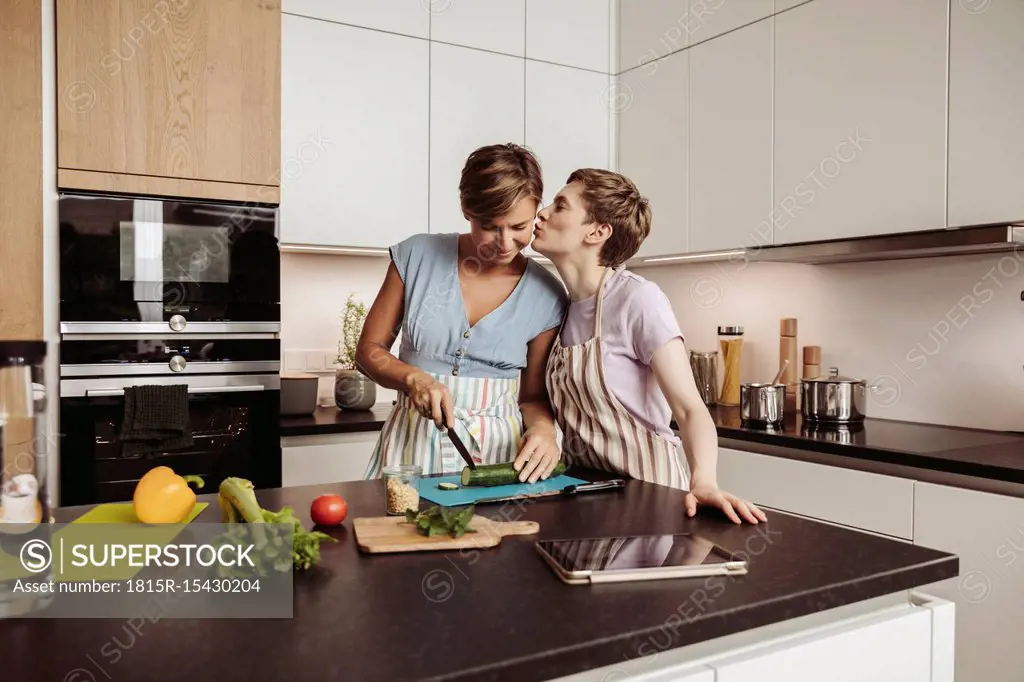 Happy lesbian couple in kitchen cooking together