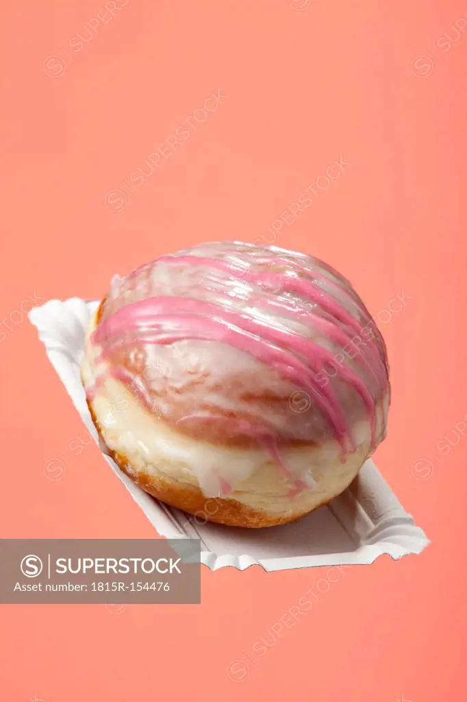 Pink decorated Bismarck doughnut on paper plate
