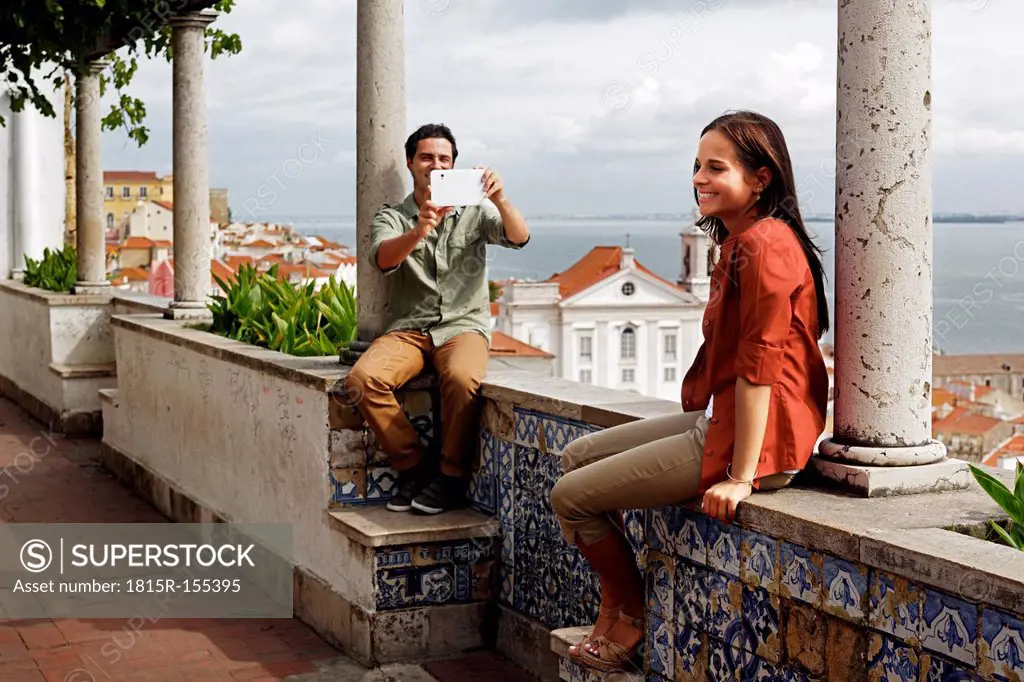 Portugal, Lisboa, Alfama, Miradouro de Santa Luzia, young man photographing with mini tablet