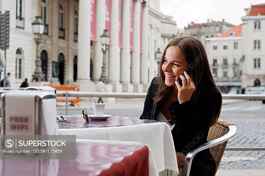 Portugal, Lisboa, Baixa, Rossio, Praca Dom Pedro IV, Teatro Nacional, young woman telephoning at street cafe