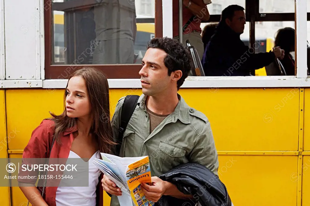 Portugal, Lisboa, Baixa, Rossio, young couple with city map in front of tram