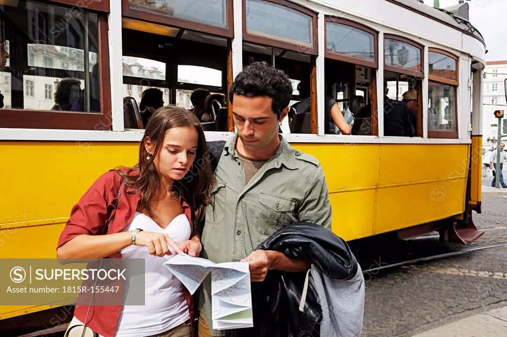 Portugal, Lisboa, Baixa, Rossio, young couple with city map in front of tram
