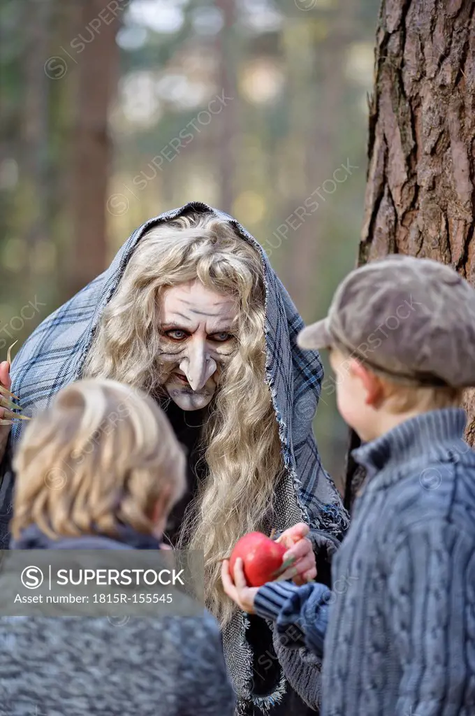 Germany, North Rhine-Westphalia, Moenchengladbach, Scene from fairy tale Hansel and Gretel, witch offering an apple to the children
