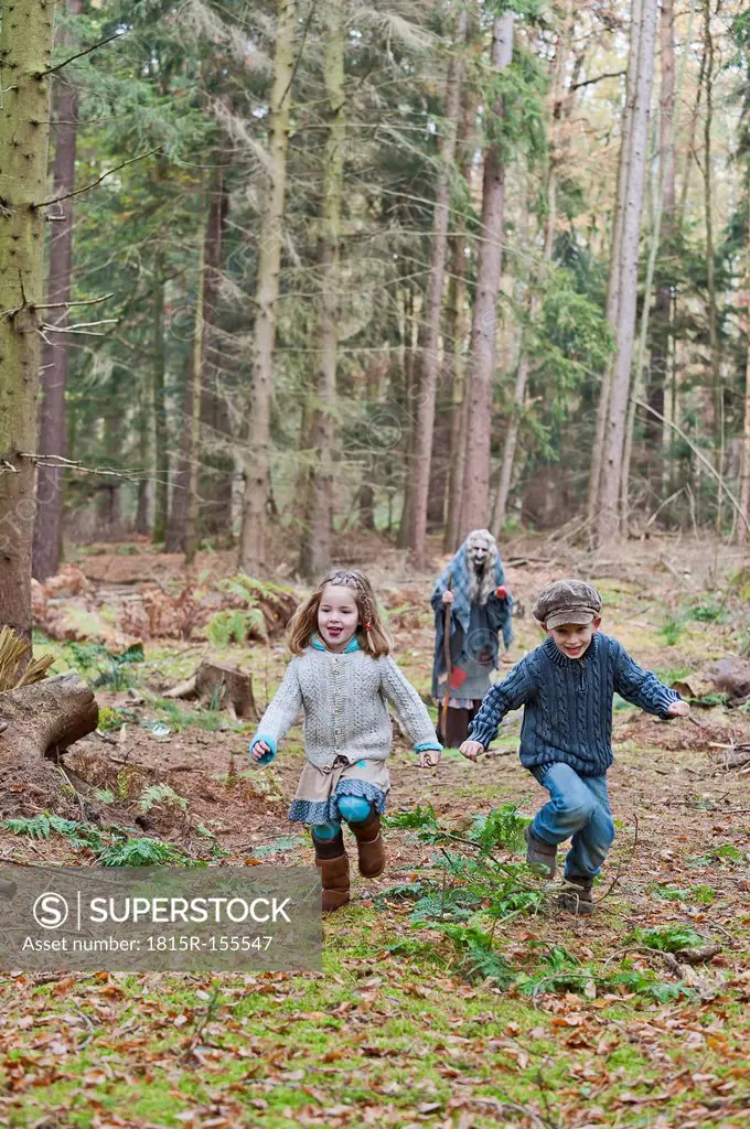 Germany, North Rhine-Westphalia, Moenchengladbach, Scene from fairy tale Hansel and Gretel, children running from witch