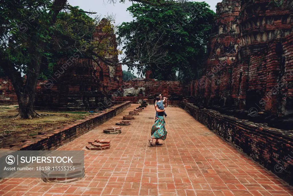 Thailand, Ayutthaya, Mother and daughter dancing in the ancient ruins of a temple at Wat Mahathat