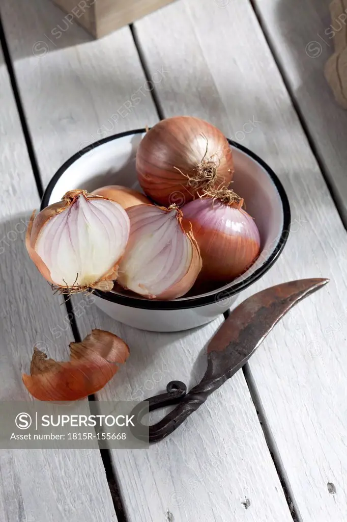 Onions in bowl on wooden table