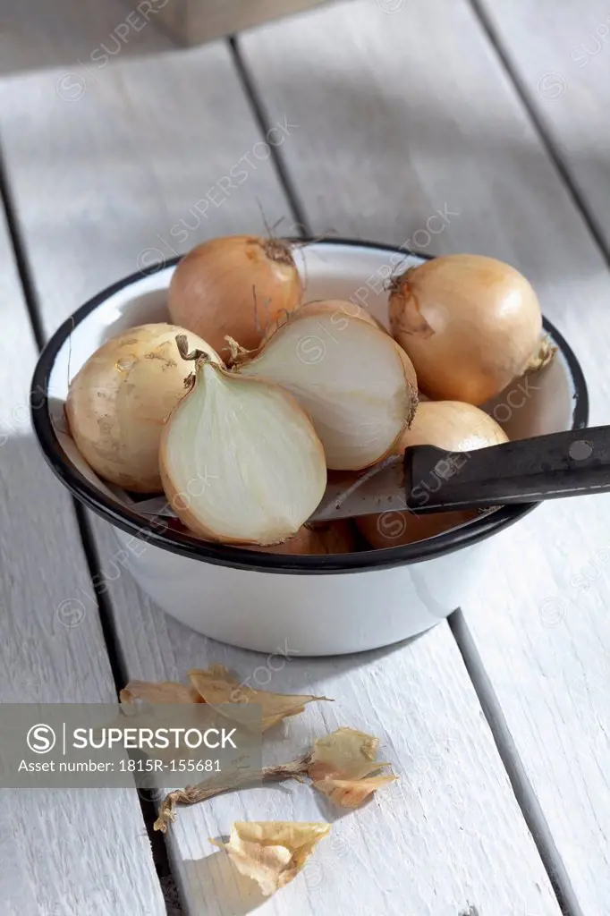 Onions in bowl on wooden table
