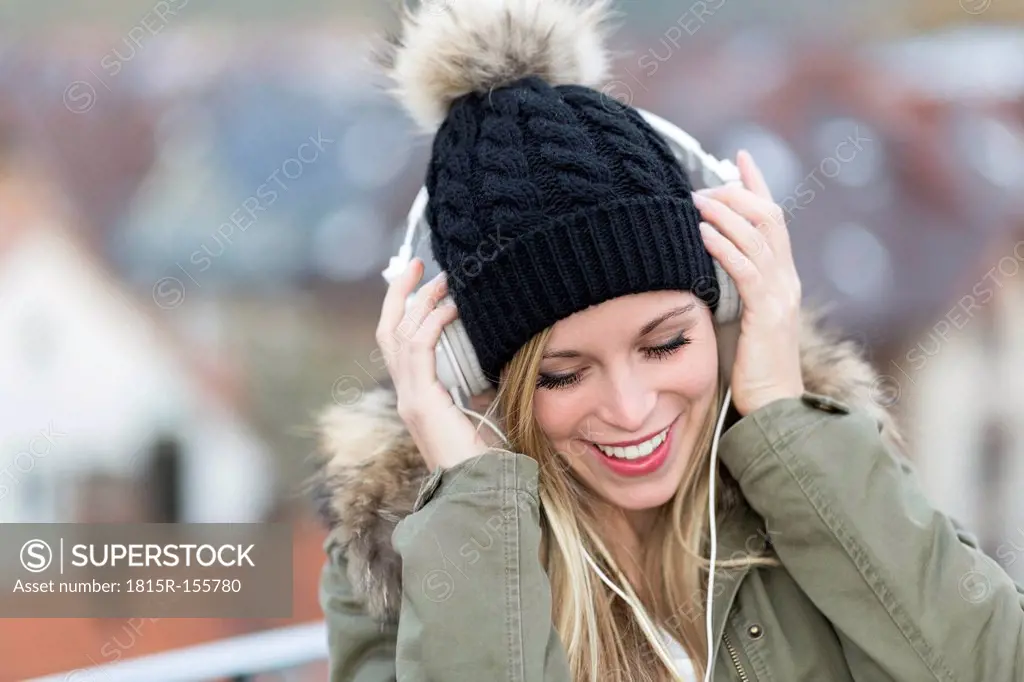 Portrait of smiling young woman with headphones, close-up