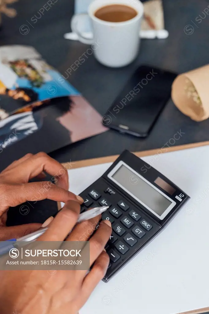 Hand of a woman using calculator