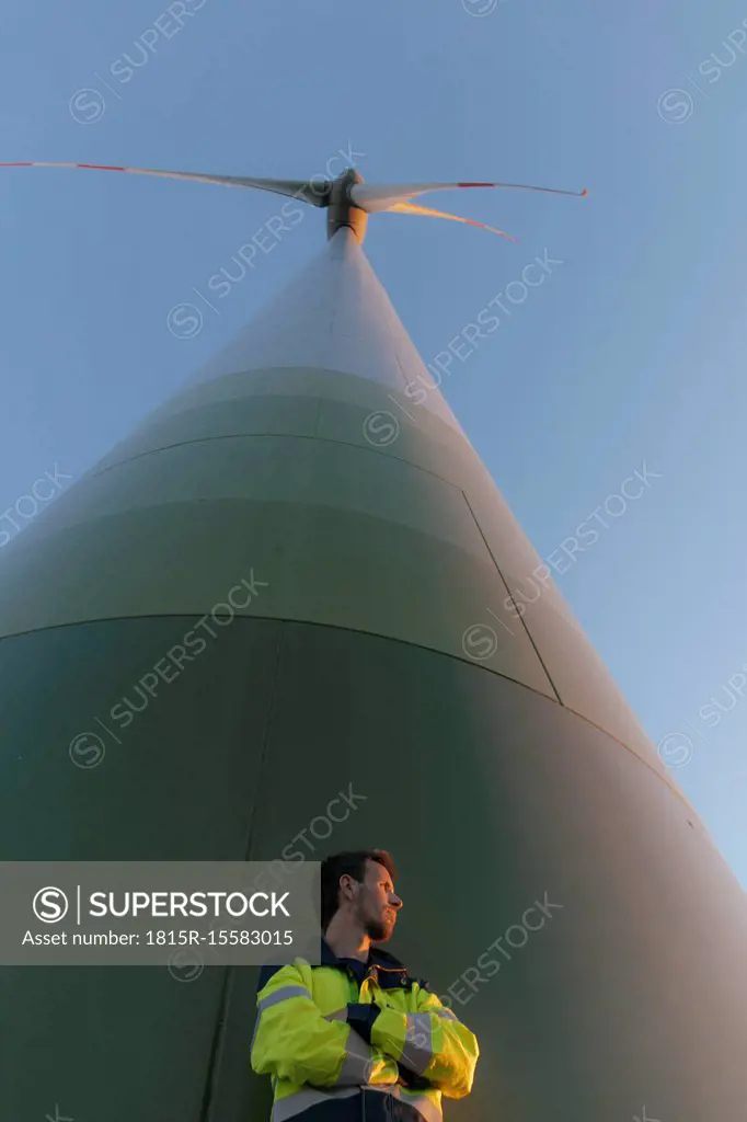 Low angle view of engineer standing at a wind turbine