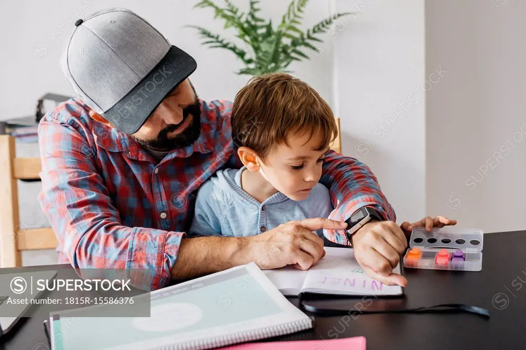 Father texplaining his son the smartwatch, while working at home