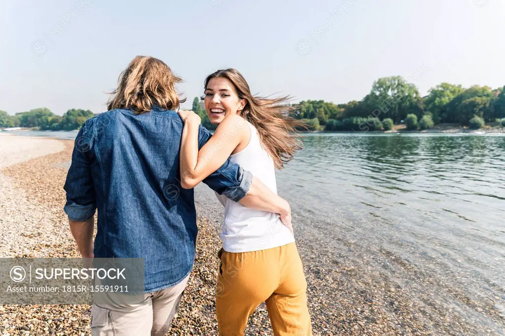 Happy young couple in love walking at the riverside