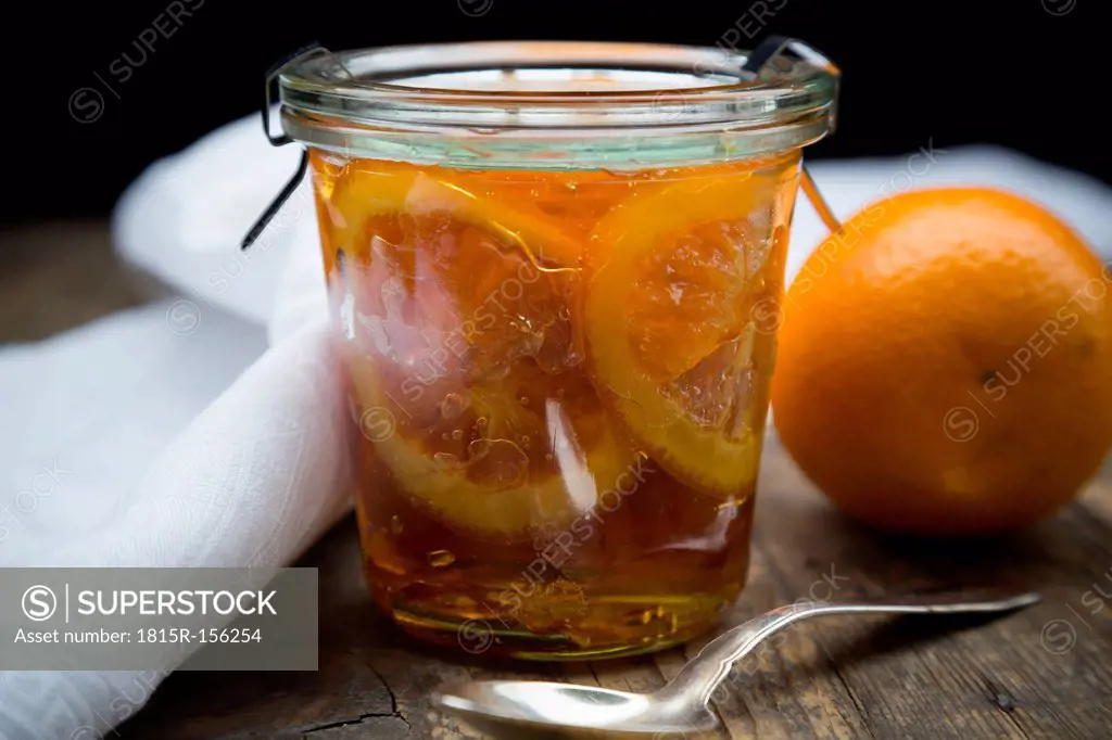 Glass of orange marmalade with orange slices