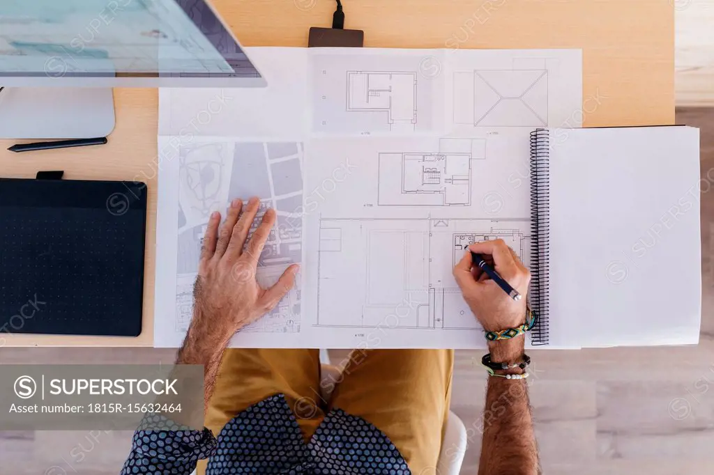 Close-up of architect working at home on floor plan