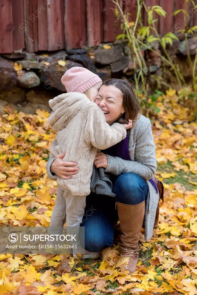 Finland, Kuopio, mother and little daughter cuddling together in autumn
