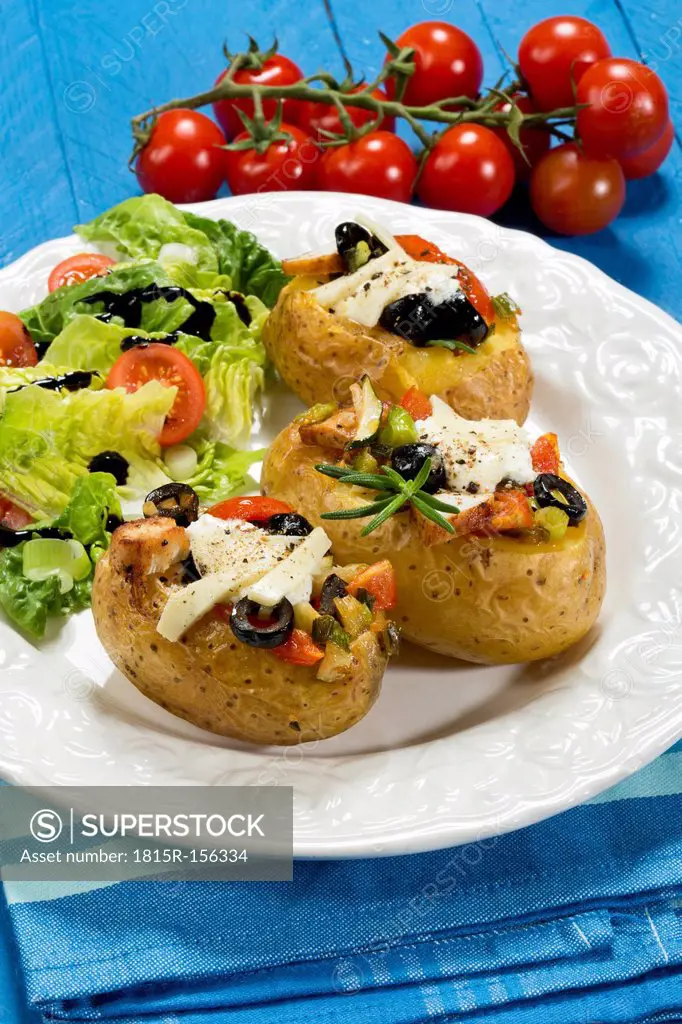 Mediterranean baked potatoes with tomatoes, spring onions, olives, chicken, ricotta and parmesan cheese