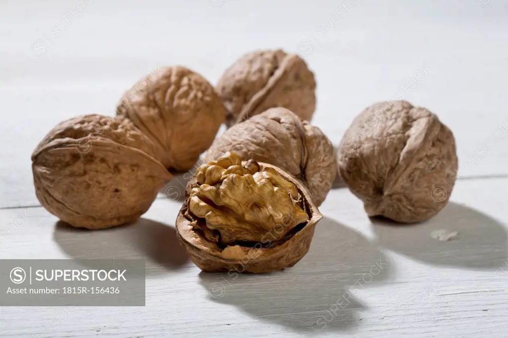 Walnuts (Juglans regia) on white wooden table