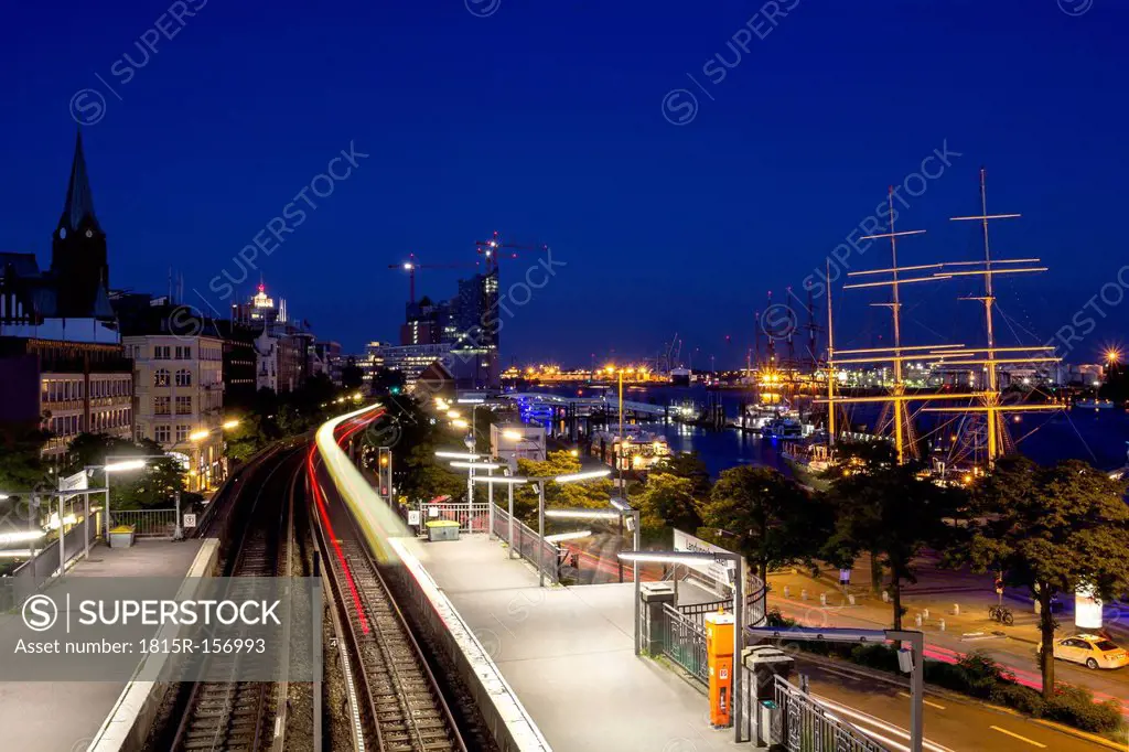 Germany, Hamburg, Ships on River Elbe and moving train at night