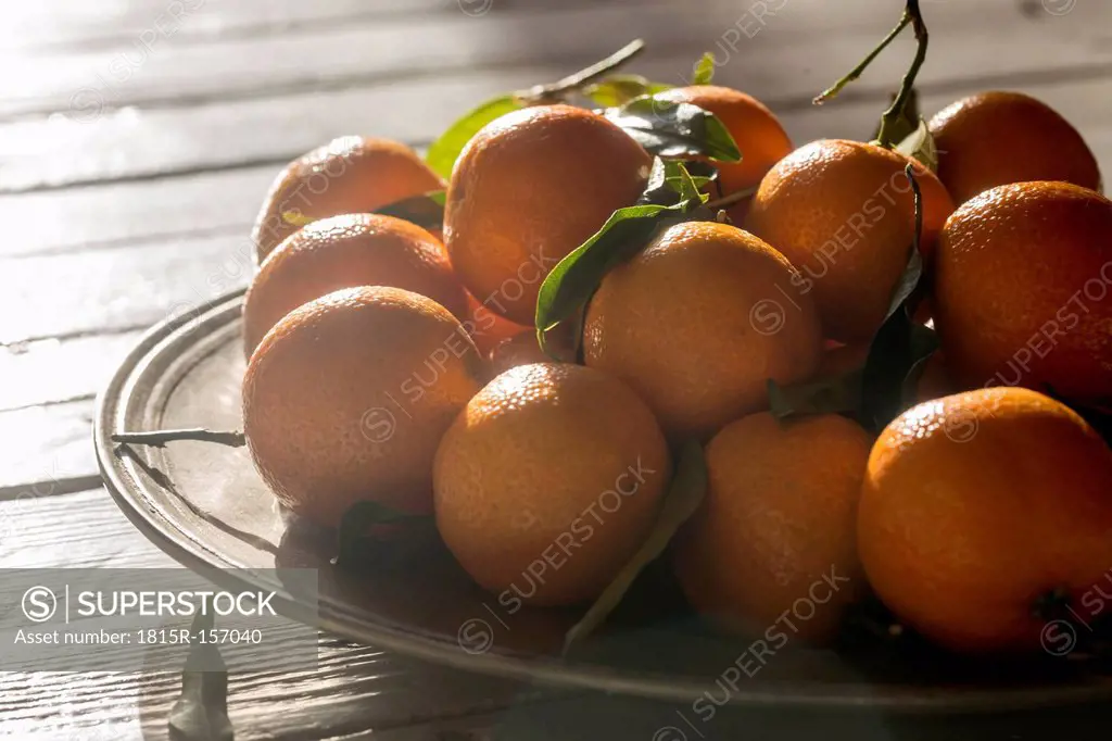 Tangerines in bowl on wooden table