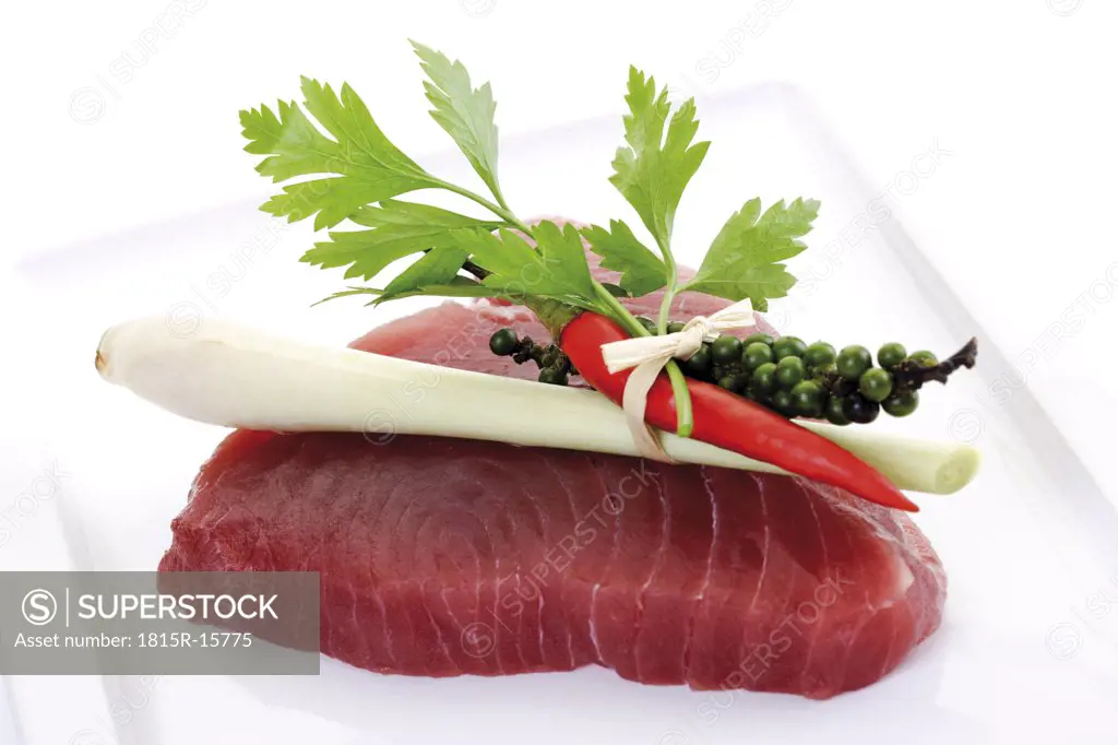 Raw tuna steak garnished with lemongrass, close-up