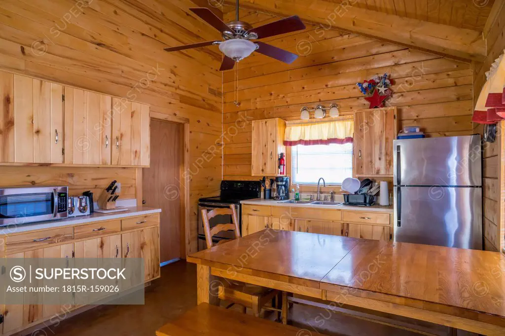 USA, Texas, rustic log home cabin interior with kitchen and dining area