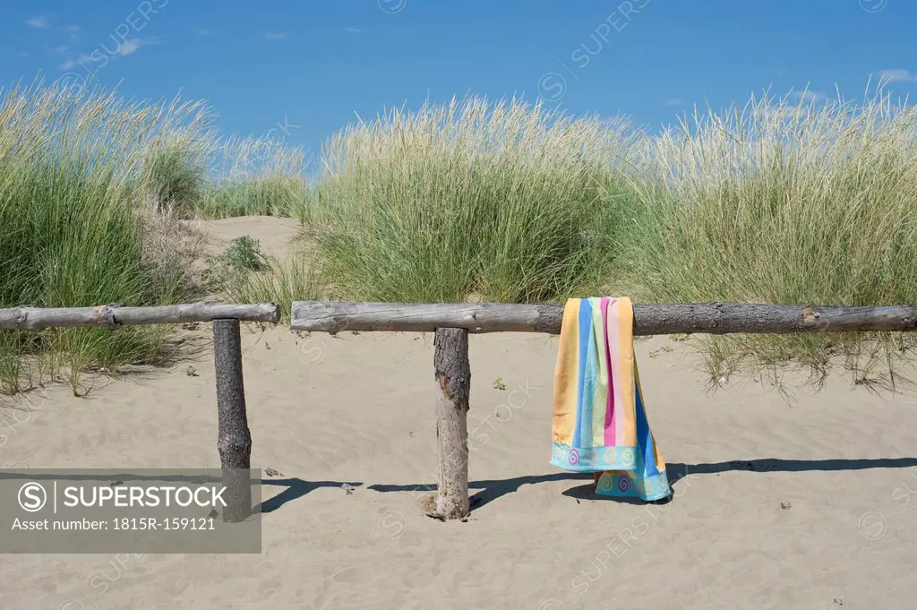 Italy, Bath towel on railing at beach dunes at Adriatic sea